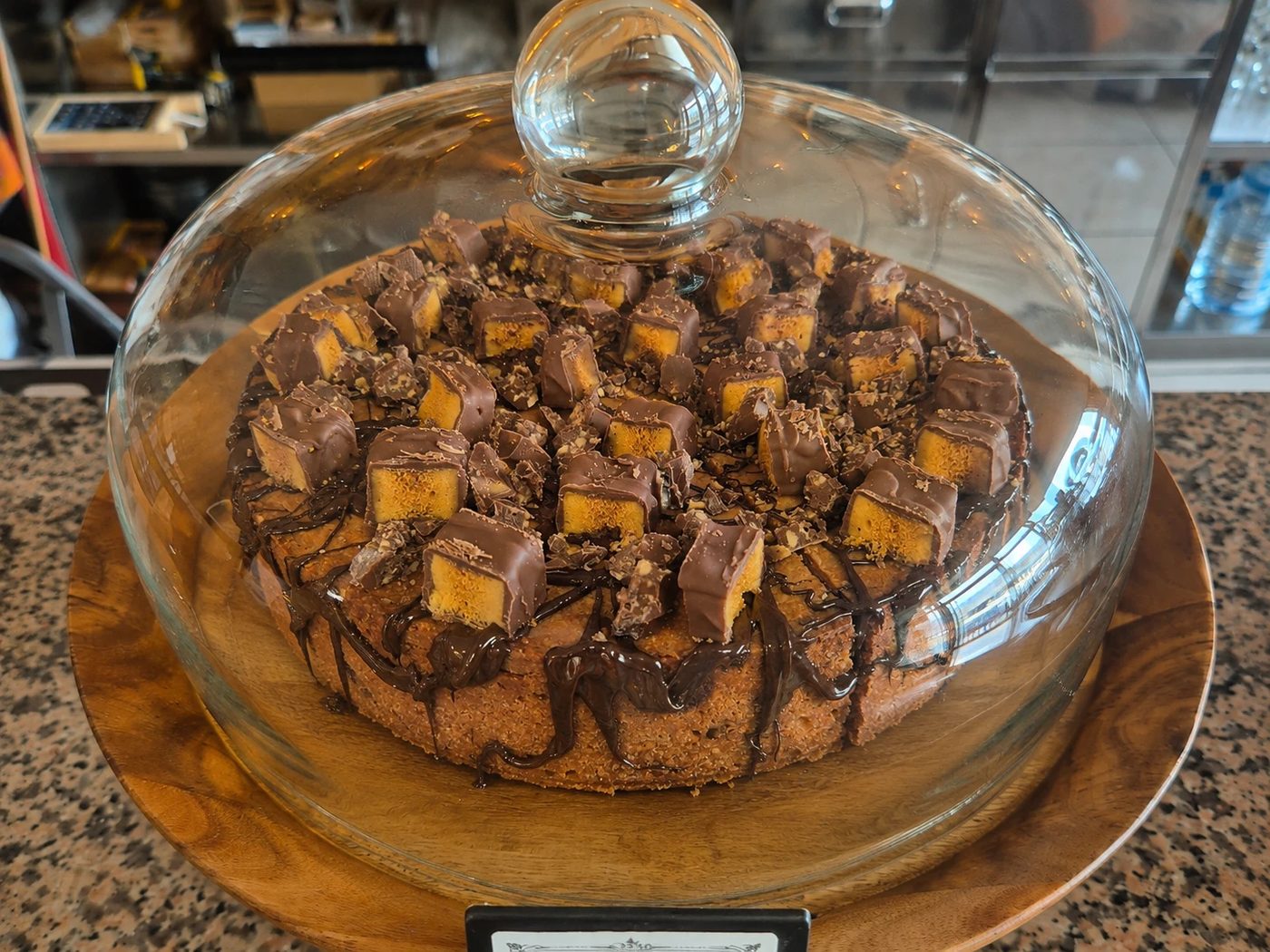 Chocolate caramel cake under a glass dome